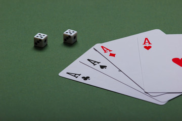 Four aces with dice on a green background.