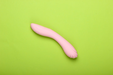 Sex toy for women on a green background. Top view, minimalism