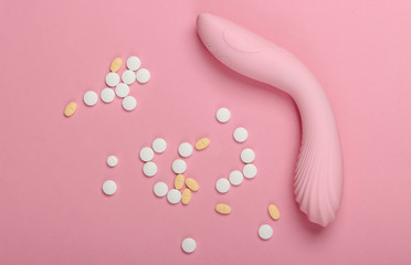 Sex toy and pills on a pink pastel background. Sex stimulants. Top view