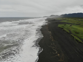 crAerial shot. Volcanic sand beach on the Pacific Ocean.