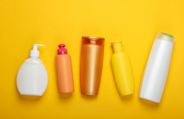 Shampoo bottles on yellow background. Hair care. Hygiene and cosmetics. Beauty flat lay. Top view