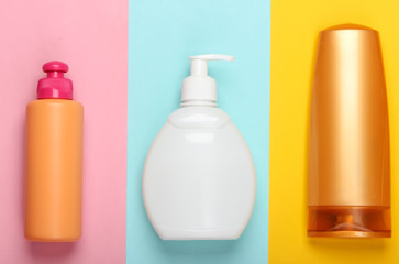 Shampoo bottles on colored background. Hair and body care. Hygiene and cosmetics. Beauty flat lay. Top view