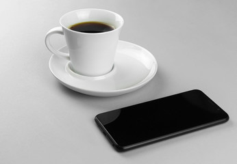 Fototapeta na wymiar coffee Cup and smartphone on a blue background.