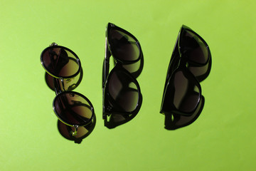 Stylish women's sunglasses on a green background.