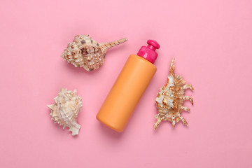 Bottle of shampoo with minerals and sea shells on a pink background. Hair care. Top view. Flat lay