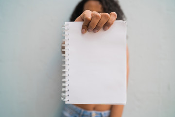 Young afro woman holding blank paper.