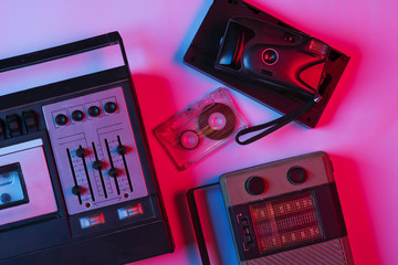 Retro audio tape recorder, audio cassette, camera, radio receiver in pink bue gradient neon light....