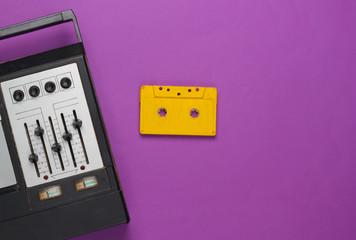 Retro audio tape recorder and audio cassette. Retro media on purple background. Top view. 80s