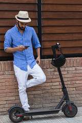 Handsome man with electric scooter looking his smartphone