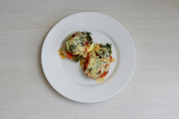 baked zucchini with vegetables on a white plate, for proper nutrition,