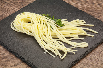 Chechil spaghetti cheese over board