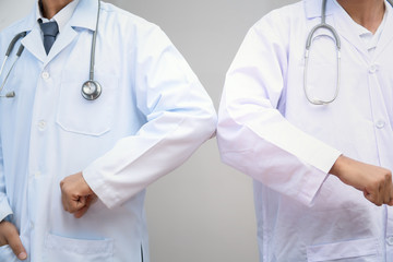 Elbow bump. New novel greeting to avoid the spread of coronavirus. Two doctor friends meet in The...