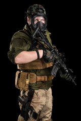 Fototapeta premium Police officer in gas mask with assault rifle. Uniform conforms to elite task force of the United States. Shot in studio. 