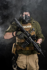 Police officer in gas mask with assault rifle. Uniform conforms to elite task force of the United...