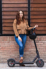 Fototapeta na wymiar Woman with electric scooter on the street