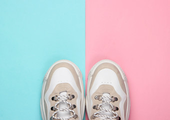 Fashionable sneakers on pink blue background. Top view. Minimalism