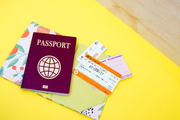 Pasaporte y tickets de transporte sobre fondo amarillo