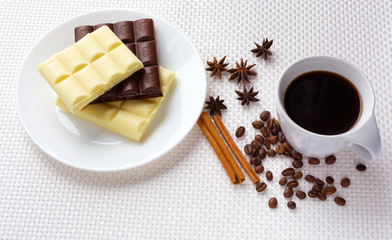aromatic cup of coffee with porous chocolate among coffee beans, star anise and cinnamon sticks on a white background