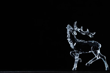 Fototapeta premium Glass figurine of a deer on a black background 