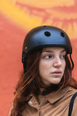 Young woman with scooter helmet on the street