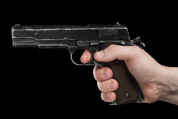 Legendary U.S. Army handgun Colt 1911A1 in male hand isolated on black background. Military model...