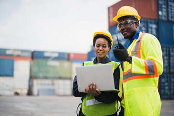 Young African american men and woman worker Check and control loading freight Containers by use...