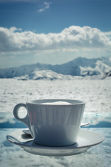 A cup of coffee against the backdrop of the mountains