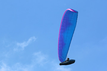 Paraglider flying wing in a blue sky