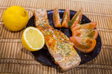 salmon fish dish with tomato, lemon and parsley