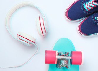Naklejka premium Hipster fashion look. Glitch effect. Skate, sneakers, headphones on a white background. Top view. Flat lay