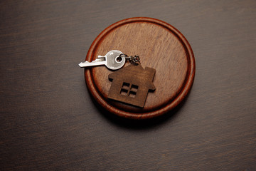 Judge gavel and key chain in shape of two splitted part of house on wooden background. Concept of...