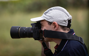 A portrait of a photographer shooting outdoors and looking happy