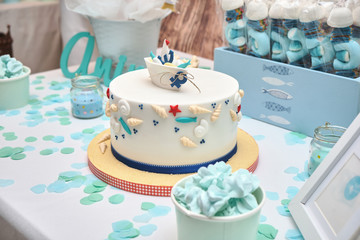 Nautical theme decoration for birthday table cake. Food sweets treats for happy children: cake, candy, marshmallow, cookies, meringue... Deco inspiration for 1st year baby anniversary.