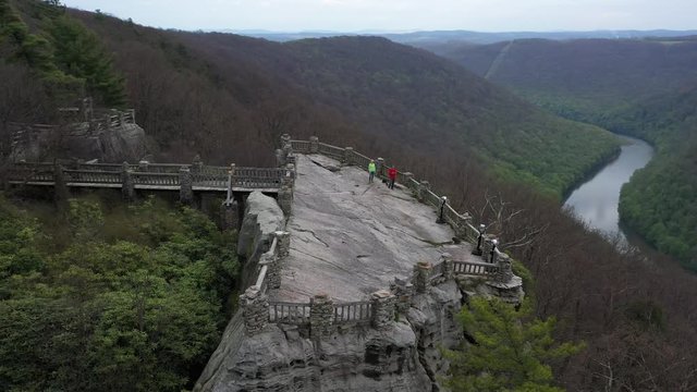Closeup aerial view trucking to the left and turning keeping the Coopers Rock overlook with panoramic views of the surrounding mountains and river.