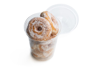 Mini ring doughnuts in plastic glass isolated in white