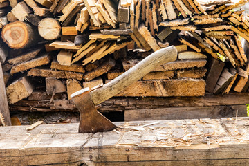 Axe in block on firewood just chopped background