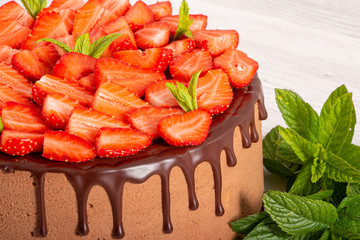 Mousse cake with profiteroles inside and strawberries