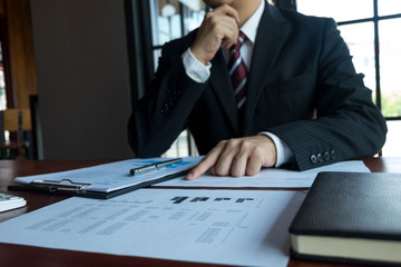 Businessman working with income statement document on the wood table.Business concept.