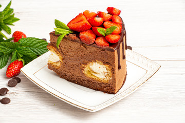 Mousse cake with profiteroles inside and strawberries