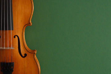 Classical music concert poster with brown color violin on dark green background with copy space for your text
