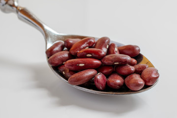 Close-up of red kidney beans on a spoon. Isolated on white background.