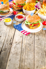 Celebrating Independence Day, July 4. Traditional American Memorial Day Patriotic Picnic with burgers,  french fries and snacks, Summer USA picnic and bbq concept, Old wooden background