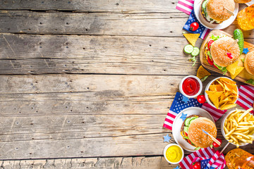 Celebrating Independence Day, July 4. Traditional American Memorial Day Patriotic Picnic with burgers,  french fries and snacks, Summer USA picnic and bbq concept, Old wooden background