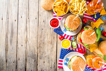 Celebrating Independence Day, July 4. Traditional American Memorial Day Patriotic Picnic with burgers,  french fries and snacks, Summer USA picnic and bbq concept, Old wooden background