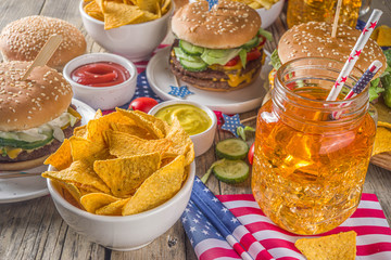 Celebrating Independence Day, July 4. Traditional American Memorial Day Patriotic Picnic with burgers,  french fries and snacks, Summer USA picnic and bbq concept, Old wooden background