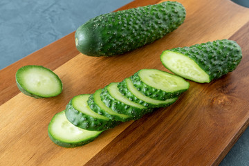 Cut into pieces fresh cucumber on a cutting board. Fresh vegetables, vegetarianism, a healthy food concept. Horizontal orientation. 