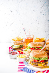 Celebrating Independence Day, July 4. Traditional American Memorial Day Patriotic Picnic with burgers, french fries and snacks, Summer USA picnic and bbq concept, White concrete background