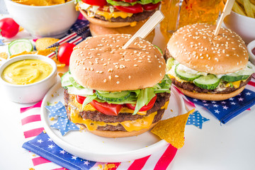 Celebrating Independence Day, July 4. Traditional American Memorial Day Patriotic Picnic with burgers, french fries and snacks, Summer USA picnic and bbq concept, White concrete background
