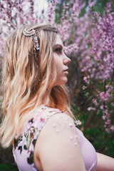 Naklejka premium Girl in a delicate dress with mehendi on the body, in flowering almonds