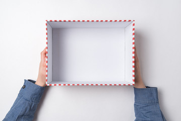 Open empty gift box in children's hands on white background. Top view.
